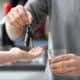 driver handing over car keys while holding a drink